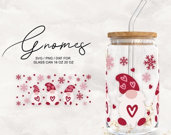 May include: Three gnomes with red hats and white beards are on a glass tumbler with a straw. The tumbler has a wooden lid and is decorated with pink snowflakes and hearts. The gnomes are wearing red and white hats and have pink cheeks. The text "Gnomes SVG/PNG/DXF for Glass Can 16 oz 20 oz" is at the top of the image.