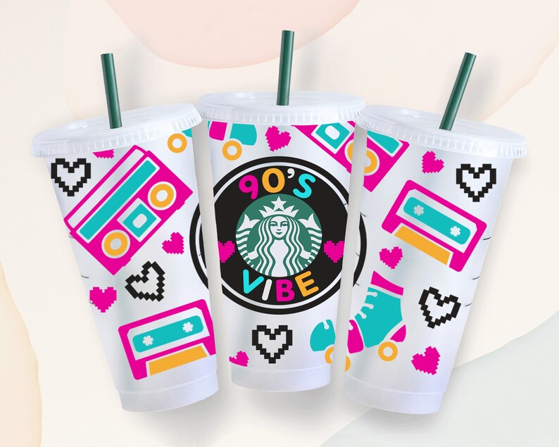 May include: Three clear plastic cups with lids and straws, decorated with a 90's theme. The cups feature a pink and blue cassette tape, pink hearts, and a green and black Starbucks logo with the text "90's Vibe".