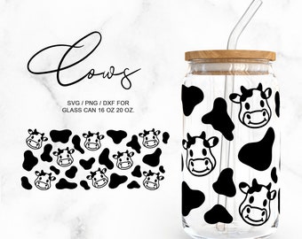 May include: A clear glass can-shaped tumbler with a wooden lid and a glass straw. The tumbler features a black and white cow pattern and cow faces. The word "Cows" is written in a cursive font. The text "SVG / PNG / DXF FOR GLASS CAN 16 OZ 20 OZ." is also present.