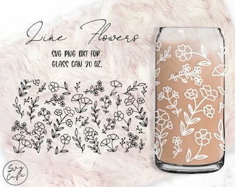May include: A clear glass can with a white floral design and the words "Line Flowers". The glass is filled with a light brown liquid. The design includes various flowers and leaves. The text "SVG PNG DXF FOR GLASS CAN 20 OZ." is also visible.