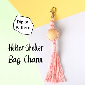 May include: Digital pattern for a pink and wooden Helter-Skelter bag charm. The charm features a wooden bead and a tassel.