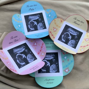May include: Four pink, blue, and yellow cards with ultrasound images and the text "Tu vas &ecirc;tre Papy!" "Tu vas &ecirc;tre Mamie!" "Tu vas &ecirc;tre Tata!" and "Tu vas &ecirc;tre Nonton!" with the word "Surprise 2023" on each card.