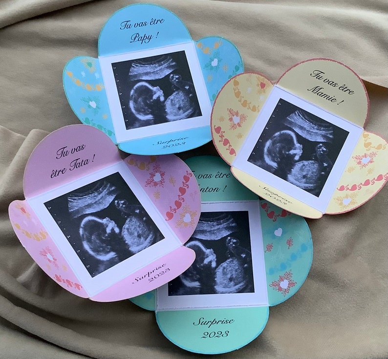 May include: Four pink, blue, and yellow cards with ultrasound images and the text "Tu vas &ecirc;tre Papy!" "Tu vas &ecirc;tre Mamie!" "Tu vas &ecirc;tre Tata!" and "Tu vas &ecirc;tre Nonton!" with the word "Surprise 2023" on each card.
