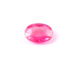 Puede incluir: Una piedra preciosa ovalada de color rosa con una superficie lisa y pulida.