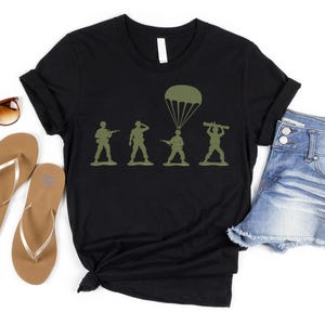 a casual outfit consisting of a black t-shirt with a graphic design, a pair of denim shorts, and a pair of flip-flops.