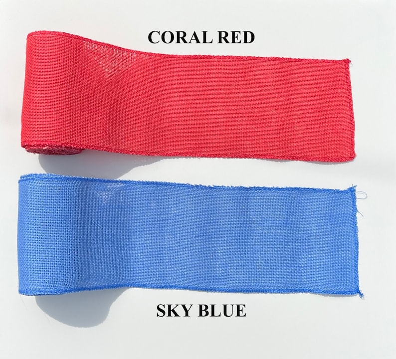 May include: Two rolls of burlap ribbon are displayed. The top roll is coral red, with the text "CORAL RED" above it. The bottom roll is sky blue, with the text "SKY BLUE" below it. The ribbon is likely used for crafts and decorations.
