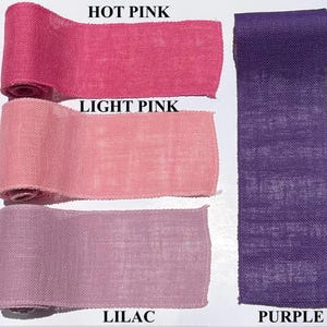 May include: A selection of burlap ribbon rolls in various shades of pink and purple. The colors include hot pink, light pink, lilac, and purple. The text labels each color. The ribbon is likely used for crafts and decorations.