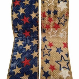May include: Two rolls of burlap ribbon, one navy blue with red and beige stars, the other beige with red, white, and navy blue stars. Suitable for patriotic or Americana-themed crafts and decorations.