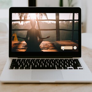 Pu&ograve; includere: Uno schermo di laptop che mostra un video di una persona che medita all'aperto. Il video ha un pulsante di iscrizione e un'icona di campana di notificazione.