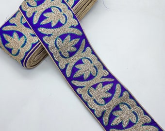Könnte beinhalten: Lilafarbener Besatz mit goldener und türkisfarbener Stickerei. Der Besatz hat ein florales Design.