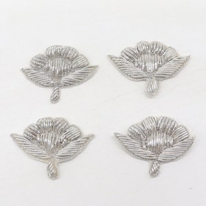 Peut inclure: Quatre appliques brodées de fleurs argentées avec un design délicat. Les appliques sont parfaites pour ajouter une touche d'élégance aux vêtements, aux accessoires ou aux projets de décoration intérieure.