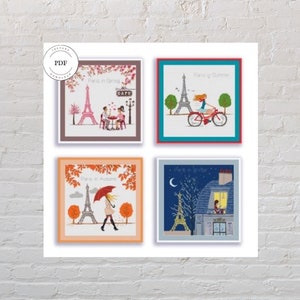 May include: Four framed cross-stitch patterns depicting the Eiffel Tower in Paris, France. Each frame features a different season: spring, summer, autumn, and winter. The spring frame shows a couple sitting at a cafe table. The summer frame shows a woman riding a bicycle. The autumn frame shows a woman walking with an umbrella. The winter frame shows a couple looking out a window.