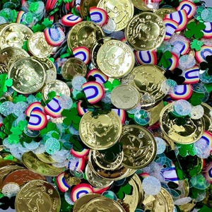 以下が含まれることがあります： 聖パトリックの日のテーマの紙吹雪の混合物のクローズアップ。 金貨、緑のシャムロック、虹の形、虹色のスパンコールが散らばっています。 コインには人の横顔があります。