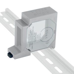 Può includere: Un interruttore intelligente Zigbee Single grigio con il marchio "tint" stampato. Montato su una guida DIN bianca. Sono mostrate opzioni di colore aggiuntive: nero, blu, grigio, rosso, giallo, verde e bianco.