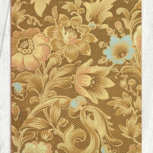 May include: A vintage floral pattern with a brown background and gold, peach, and blue flowers. The pattern is reminiscent of wallpaper or fabric.