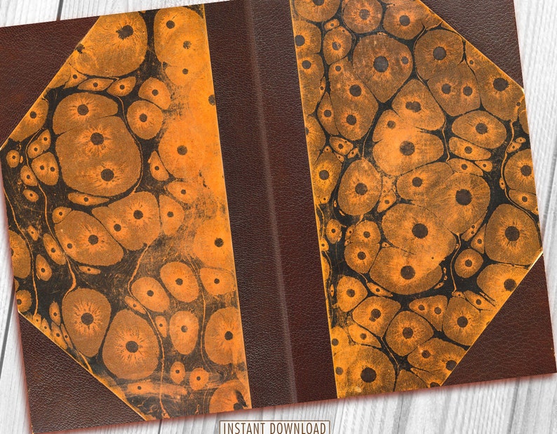 May include: Close-up of a book cover with a brown leather spine and orange marbled paper with black spots. The marbled paper has a unique pattern of swirling circles and dots.