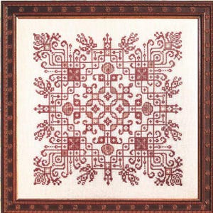May include: Framed cross-stitch artwork featuring a symmetrical design in shades of red and brown. The intricate pattern includes geometric shapes, floral elements, and a central medallion. The artwork is displayed in a dark brown wooden frame.