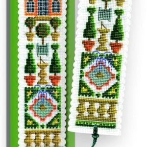 May include: A cross-stitch bookmark kit with the text "Orangery Bookmark Kit" on a green background. The bookmark features a detailed design of a building, trees, and geometric patterns in various colors. Includes a green tassel.