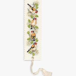 May include: A cream-colored, cross-stitched bookmark featuring four goldfinches perched on a leafy branch. The birds have red, black, and yellow markings. The bookmark has a scalloped edge and a cream-colored tassel.
