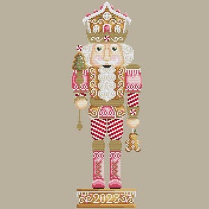 May include: A cross-stitch design of a Christmas nutcracker in shades of pink, gold, and white. The nutcracker wears a gingerbread house crown and holds a small Christmas tree. The base reads "2023".