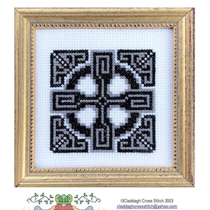 May include: A framed cross stitch design featuring a black and white Celtic labyrinth cross pattern. The cross stitch is in a gold frame with a white mat.