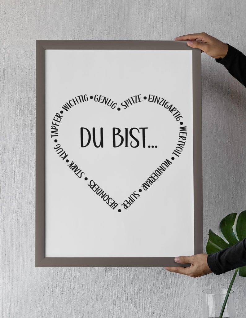 Puede incluir: Una impresi&oacute;n enmarcada con fondo blanco y texto negro. El texto dice "DU BIST..." en forma de coraz&oacute;n con palabras como "wertvoll", "wunderbar", "super", "besonders", "stark", "klug", "tapper", "wichtig", "genug", "spitze" y "einzigartig" rodeando el coraz&oacute;n.