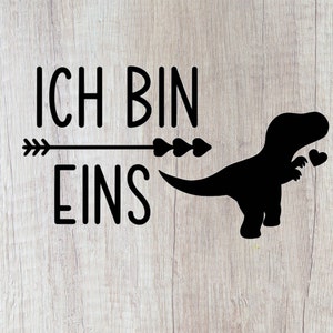 May include: Black and white graphic with the text "ICH BIN EINS" and a silhouette of a dinosaur holding two hearts.
