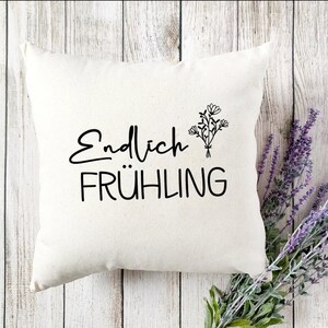 May include: White throw pillow with black text that reads "Endlich Fr&uuml;hling" and a simple black line drawing of a bouquet of flowers.