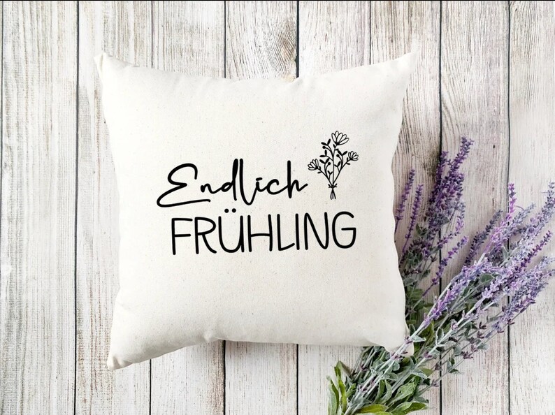 May include: White throw pillow with black text that reads "Endlich Fr&uuml;hling" and a simple black line drawing of a bouquet of flowers.