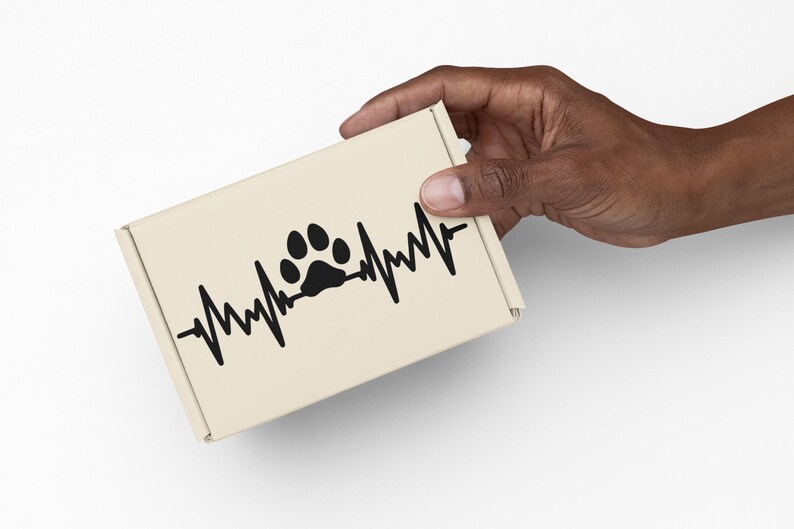 May include: A beige cardboard box featuring a black paw print design integrated into a heartbeat line. The box is held by a hand against a white background. The design suggests a pet-related theme.