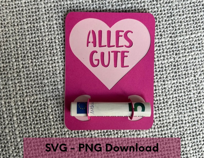 K&ouml;nnte beinhalten: Rosa Karte mit einem gro&szlig;en rosa Herz, das in der Mitte ausgeschnitten ist. Das Herz tr&auml;gt den Text "ALLES GUTE" in Wei&szlig;. Ein zusammengerollter Geldschein wird von zwei rosa Kreisen auf der Karte gehalten.