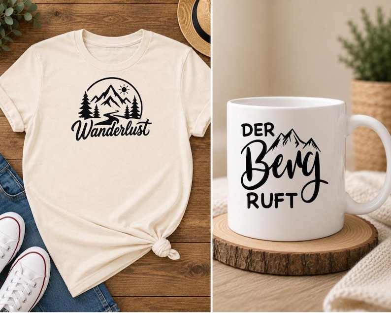 May include: A cream-colored t-shirt featuring a black graphic of mountains, pine trees, and the sun with the text "Wanderlust" and a white ceramic mug featuring a black graphic of mountains and the text "DER BERG RUFT" in a bold font.