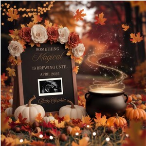 May include: A chalkboard sign with the text "Something Magical is Brewing Until April 2025" and "Baby Sophia". A black cauldron with a golden glow and a fall-themed background with pumpkins, leaves, and lights.