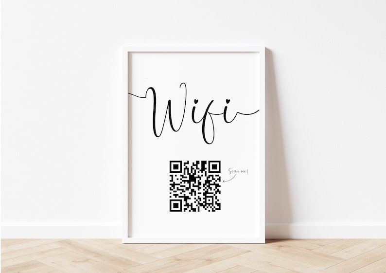 Puede incluir: Una impresi&oacute;n enmarcada en blanco con la palabra "Wifi" en escritura cursiva y un c&oacute;digo QR en blanco y negro con el texto "Scan me!" al lado.