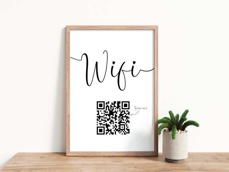 Puede incluir: Una impresi&oacute;n enmarcada con la palabra "Wifi" en cursiva con un coraz&oacute;n sobre la "i". Debajo de la palabra hay un c&oacute;digo QR en blanco y negro con una flecha que apunta a &eacute;l y el texto "&iexcl;Escaneame!"