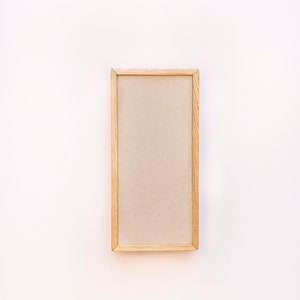 Pu&ograve; includere: Una cornice in legno semplice con un passepartout beige. La cornice &egrave; su uno sfondo bianco.