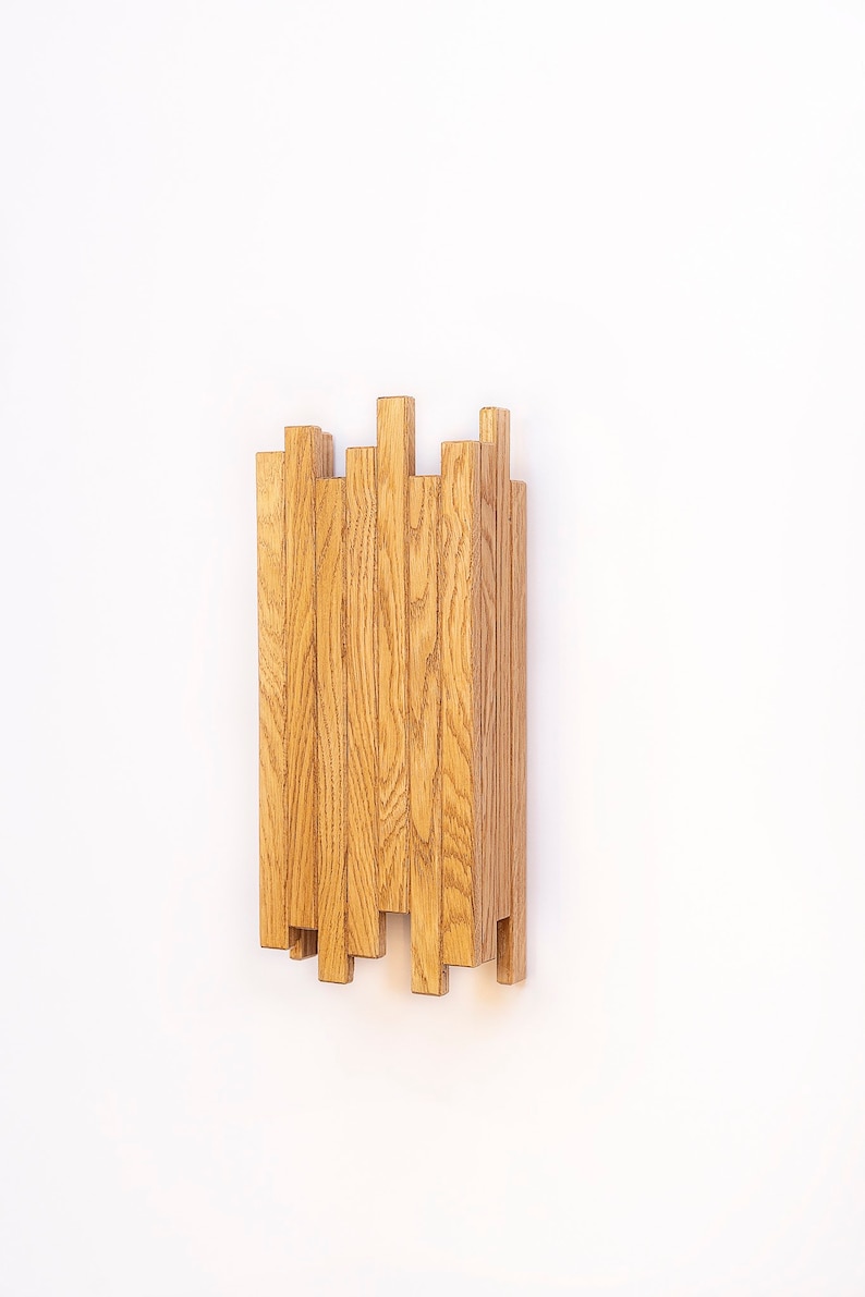 Peut inclure: Une &eacute;tag&egrave;re murale en bois au design unique. L'&eacute;tag&egrave;re est compos&eacute;e de multiples lattes de bois fines et verticales dispos&eacute;es en quinconce. Les lattes sont de couleur brun clair et pr&eacute;sentent un grain de bois naturel.