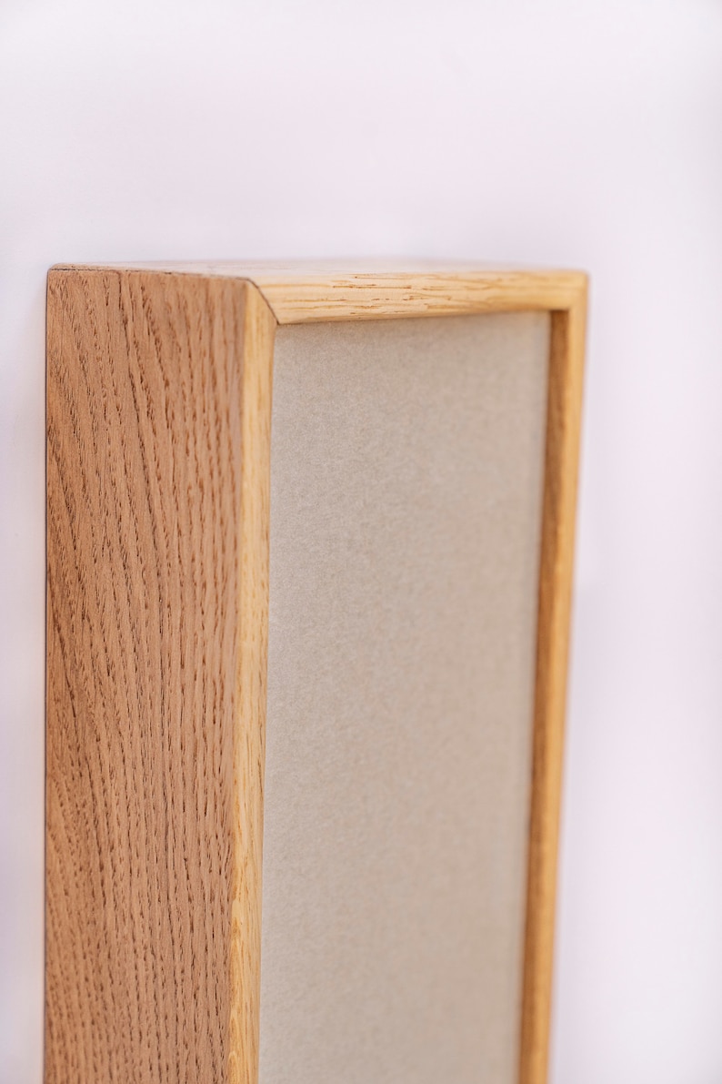 Pu&ograve; includere: Una cornice in legno con un passepartout beige chiaro. La cornice &egrave; in legno naturale con una venatura visibile.
