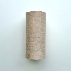 Puede incluir: Pantalla de l&aacute;mpara cil&iacute;ndrica de tela beige texturizada. La pantalla tiene una forma alta y estrecha, con un di&aacute;metro constante. El color neutro y el dise&ntilde;o sencillo sugieren una est&eacute;tica moderna o minimalista. Adecuada para l&aacute;mparas de mesa o de pie.