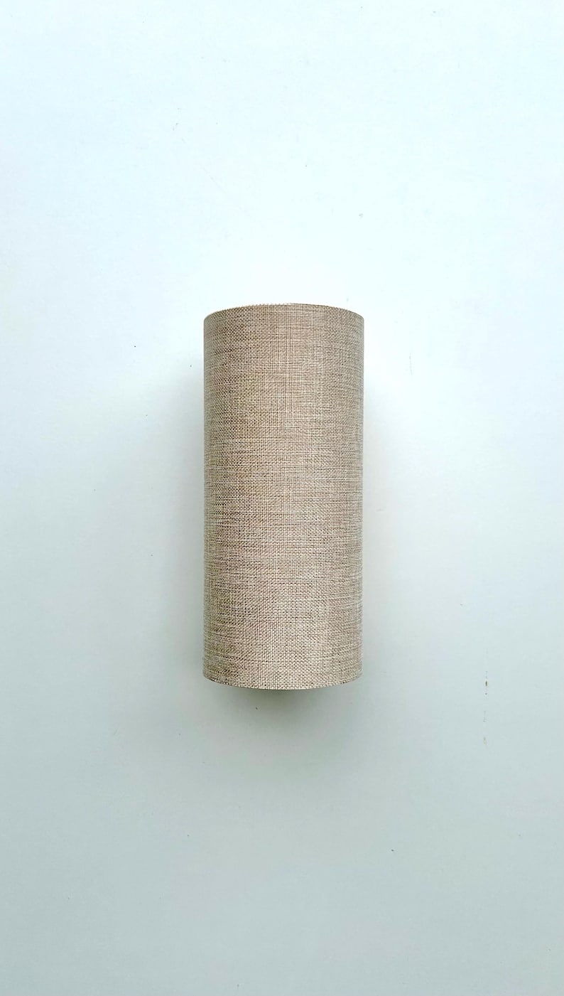 Puede incluir: Pantalla de l&aacute;mpara cil&iacute;ndrica de tela beige texturizada. La pantalla tiene una forma alta y estrecha, con un di&aacute;metro constante. El color neutro y el dise&ntilde;o sencillo sugieren una est&eacute;tica moderna o minimalista. Adecuada para l&aacute;mparas de mesa o de pie.