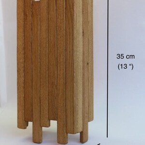 Peut inclure: Une sculpture en bois compos&eacute;e de plusieurs lattes verticales, pos&eacute;e sur une surface blanche. La sculpture mesure 35 cm de haut, 14 cm de large et 7 cm de profondeur.