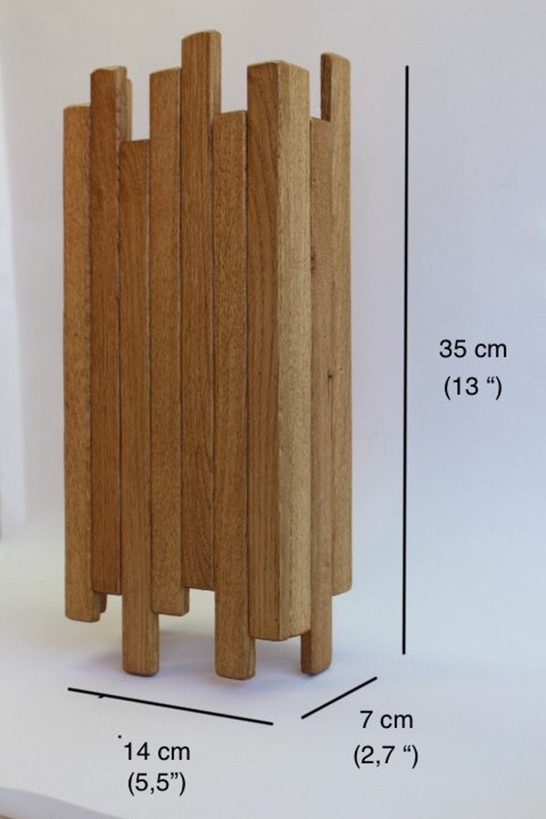 Peut inclure: Une sculpture en bois compos&eacute;e de plusieurs lattes verticales, pos&eacute;e sur une surface blanche. La sculpture mesure 35 cm de haut, 14 cm de large et 7 cm de profondeur.