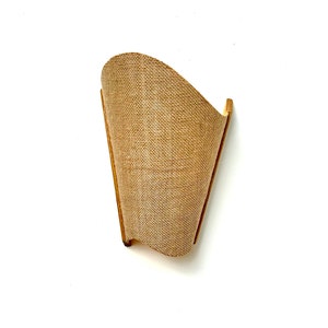 Può includere: Un'applique da parete in vimini marrone con una forma curva. L'applique è realizzata in fibre naturali e ha uno stile rustico e da fattoria.