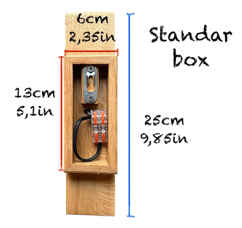 May include: A wooden electrical box with a standard size opening. The box is 9.8 inches wide and 5.1 inches tall. The box is 2.35 inches deep. The box is labeled "Standard box".