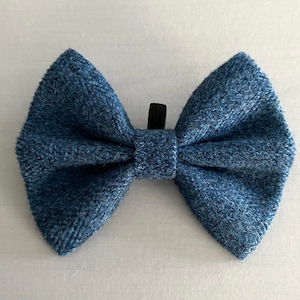 Op de afbeelding: Een denim blauwe vlinderdas met een getextureerde uitstraling. De vlinderdas is gemaakt van een geweven stof en heeft een zwarte clip aan de achterkant. Een klassiek accessoire.