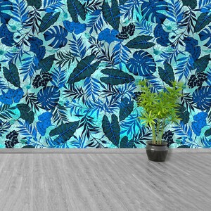 May include: A blue and green tropical leaf patterned wallpaper with a potted plant in front of it. The plant is in a black pot and has green leaves.