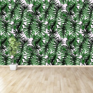 May include: A white wall with a green tropical leaf pattern. The wall is in a room with a wooden floor.