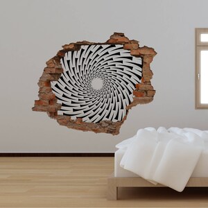 May include: A black and white swirling pattern inside a brick wall hole, creating an optical illusion. The wall is white and the background is a light wood floor.