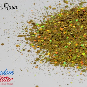 May include: Gold glitter with a holographic finish. The glitter is a mix of gold, green, and orange colors. The glitter is called "Gold Rush" and is from Freedom Glitter by Dukes Design.