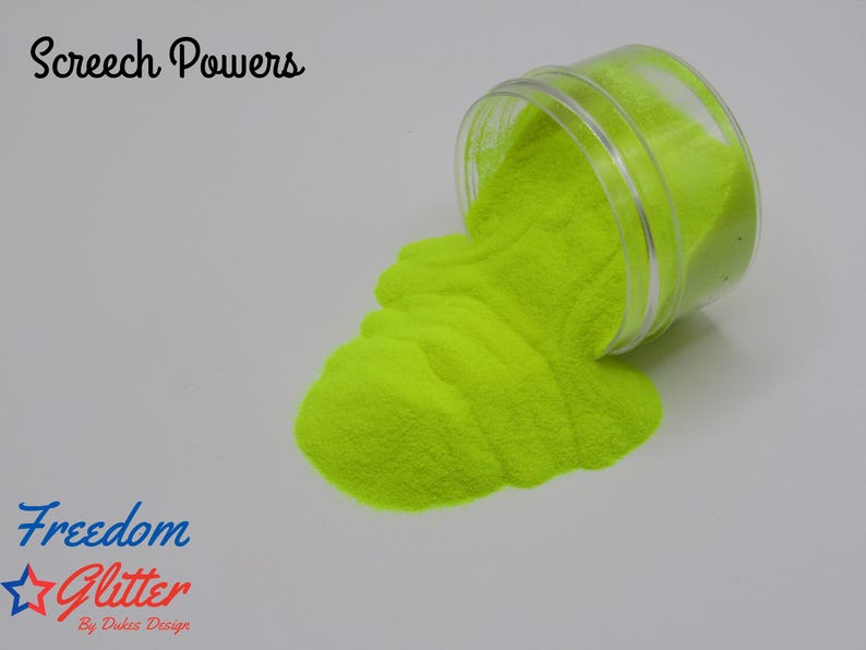 May include: A clear plastic jar tipped over, spilling bright neon yellow glitter onto a white surface. The text "Screech Powers" is above the jar, and the "Freedom Glitter" logo is below.